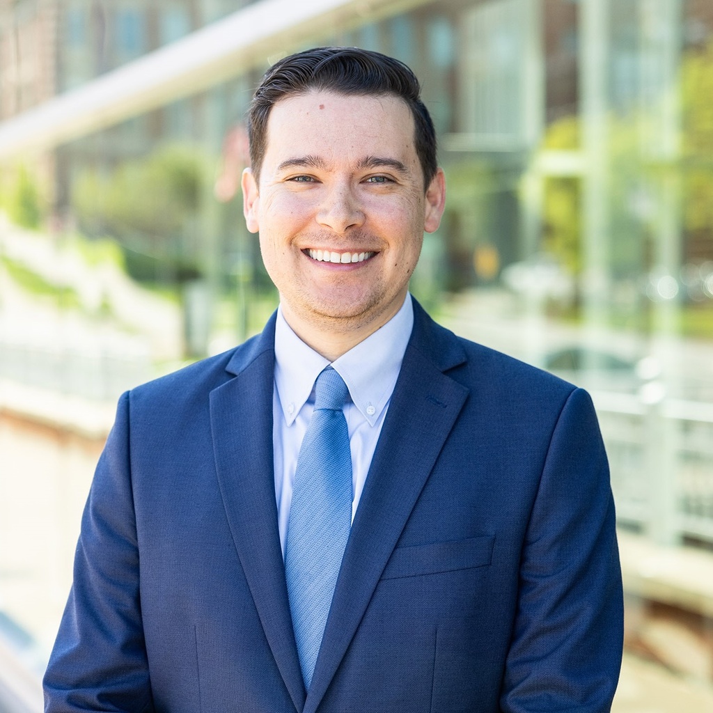 Photo of Aaron Miers wearing a blue suit.