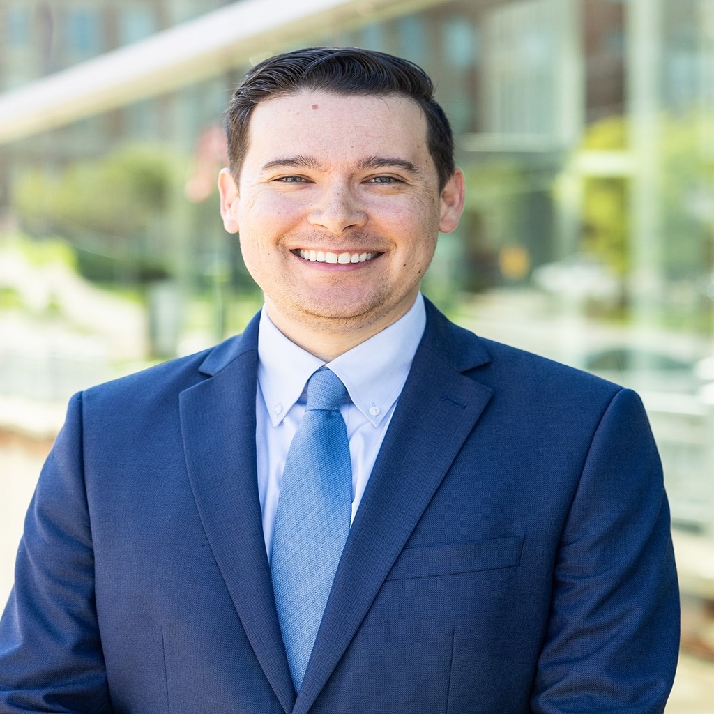 Photo of Aaron Miers wearing a blue suit.